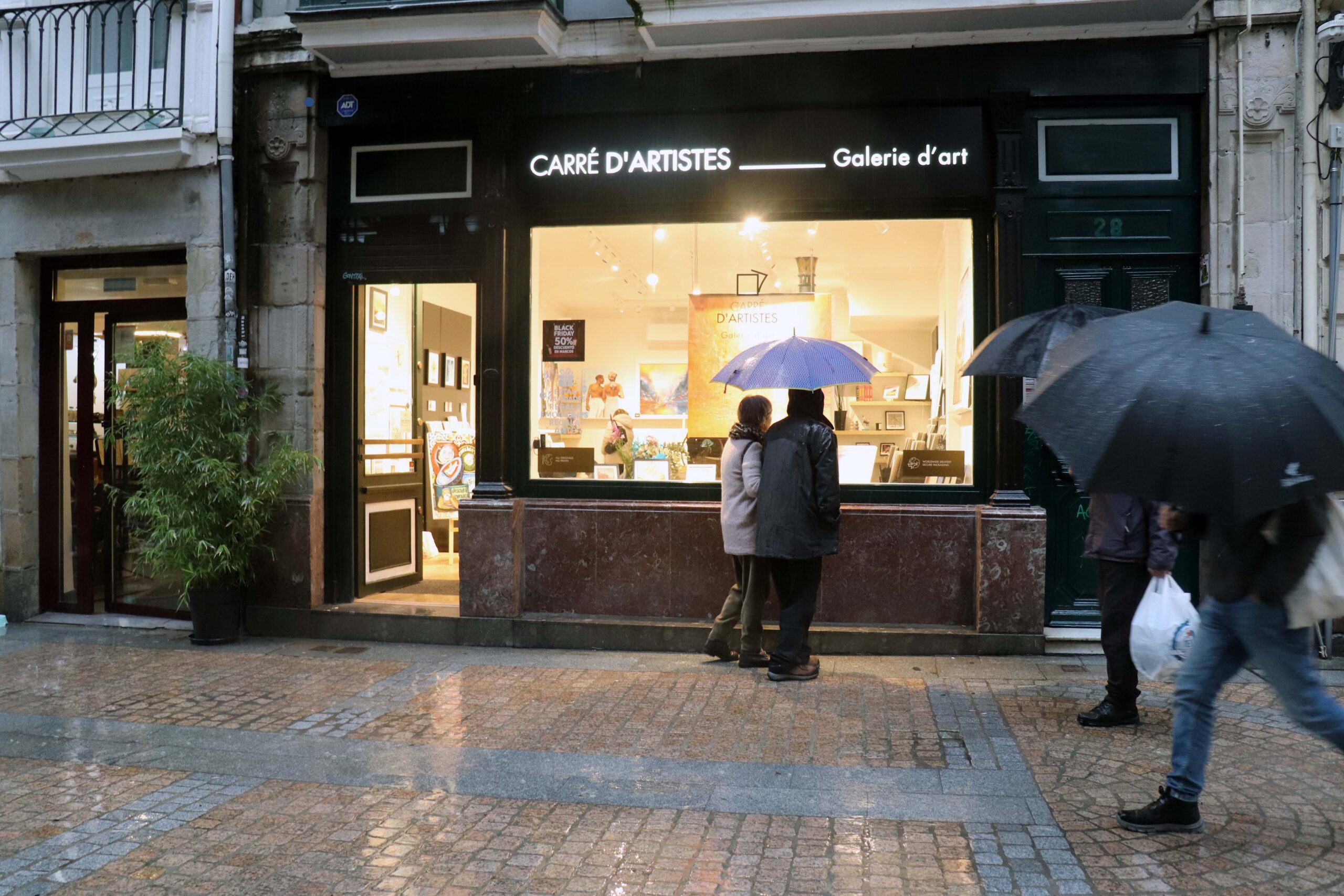 Personas pasando por la galería, en la calle Tendería